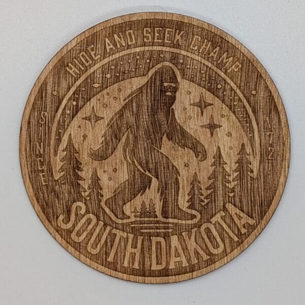 Custom wood sticker depicting a sasquatch in a forest with hide and seek champ South Dakota text