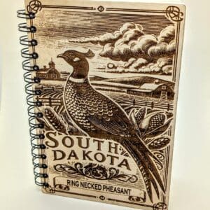 Wooden journal cover showing a South Dakota ring necked pheasant with a farm vista background