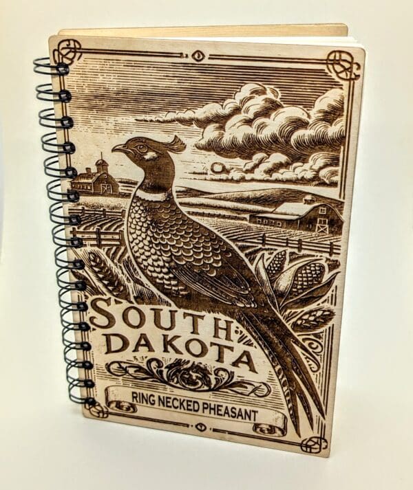 Wooden journal cover showing a South Dakota ring necked pheasant with a farm vista background