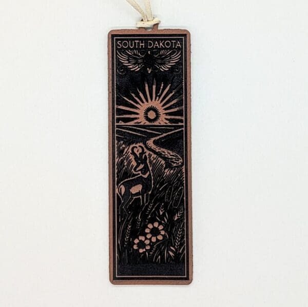 Leatherette bookmark showing an antelope and sun showing over a river in South Dakota