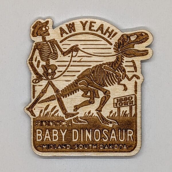 Wooden magnet depicting a skeleton man walking a skeleton dinosaur with the text bringing home a baby dinosaur Midland, South Dakota